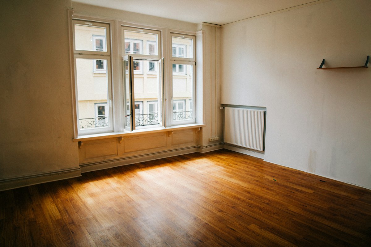 Pièce vide et lumineuse, parquet et grandes fenêtres